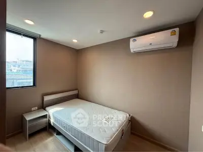 Modern bedroom with natural light, featuring a comfortable bed and air conditioning, ideal for urban living.