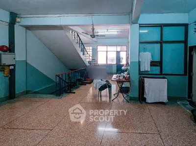 Spacious interior with staircase and tiled flooring, ideal for versatile use.