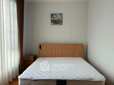 Cozy bedroom with a large window and modern decor, featuring a comfortable bed and elegant curtains.