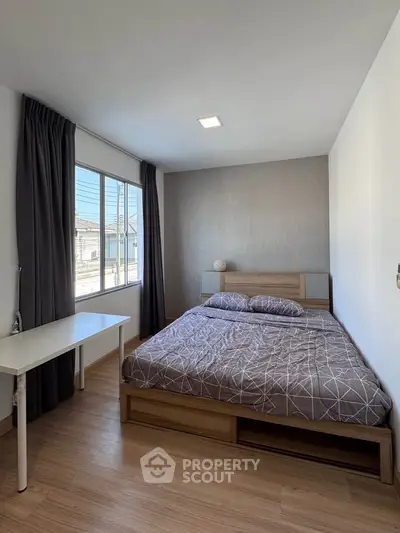 Modern bedroom with large window and stylish decor in a real estate property.