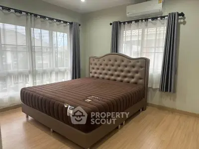 Spacious bedroom with elegant bed and large windows in modern home