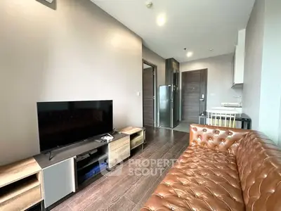 Modern living room with leather sofa and flat-screen TV in a stylish apartment.