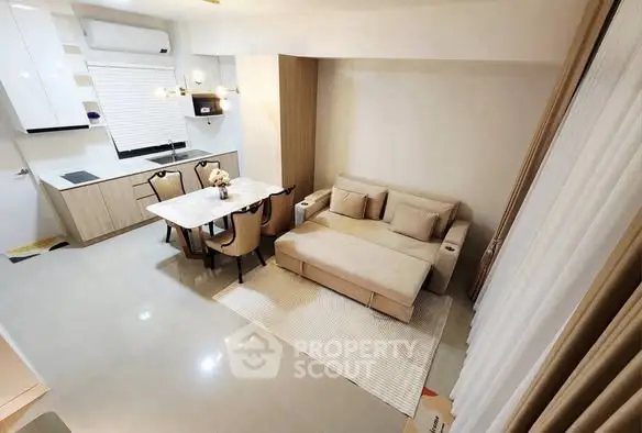 Modern living room with cozy sofa and dining area in open layout apartment.