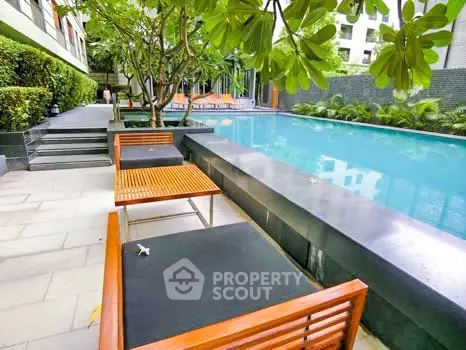 Luxurious outdoor pool area with modern lounge chairs and lush greenery