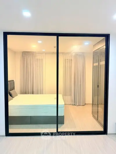 Modern bedroom with glass sliding doors and elegant curtains