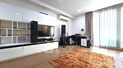 Spacious modern living room with sleek entertainment center and cozy workspace