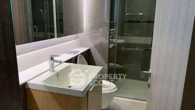 Modern bathroom with sleek design featuring a glass shower and stylish vanity.