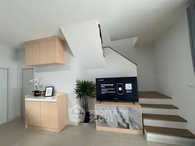 Modern living room with stylish staircase and sleek TV setup