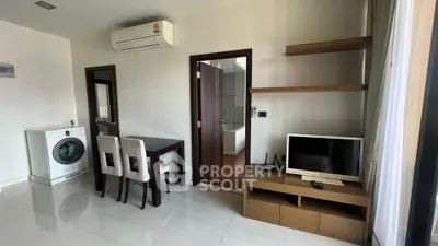 Modern living room with washing machine and TV, open layout design.