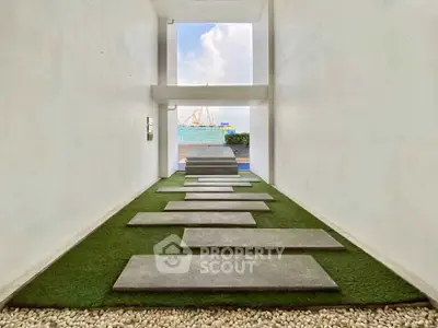 Modern minimalist entrance with stepping stones and lush greenery