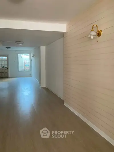 Spacious interior with wooden flooring and elegant wall lighting, perfect for modern living.