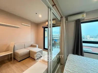 Modern apartment with cozy living room and bedroom, featuring large windows and city view.