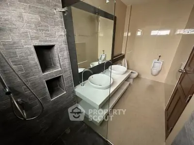 Modern bathroom with dual sinks and glass shower enclosure