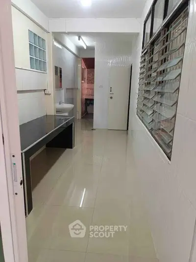 Spacious kitchen with sleek countertops and ample natural light.