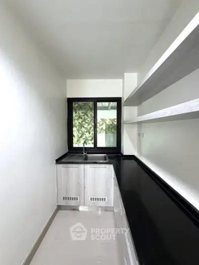 Sleek modern kitchen with black countertops and open shelving