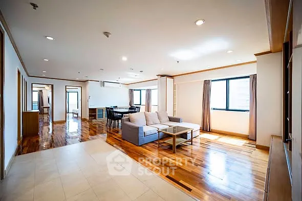Spacious open-plan living room with hardwood floors and natural light