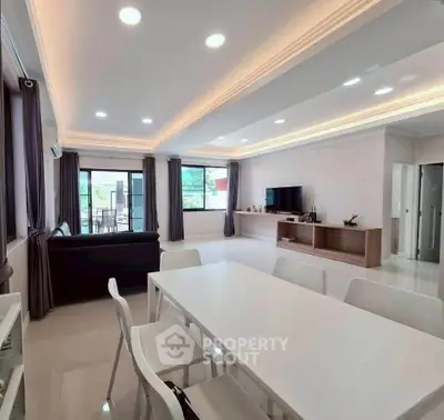 Spacious modern living room with elegant lighting and sleek furniture, perfect for family gatherings.
