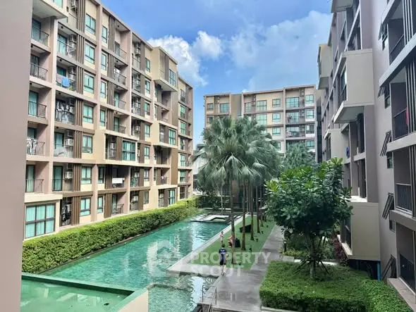 Modern apartment complex with pool and lush greenery, perfect for urban living.