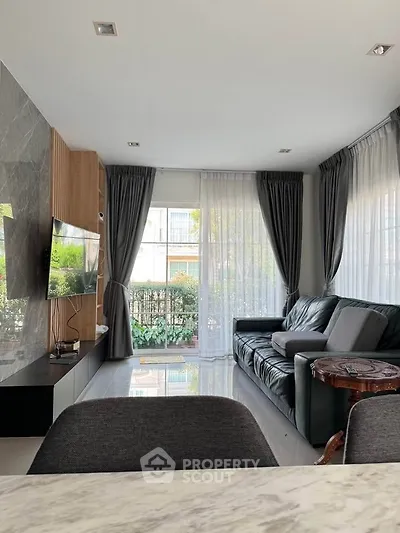 Spacious living room with modern decor and large windows for natural light.