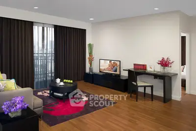 Spacious living room with modern decor and balcony view, featuring hardwood floors and elegant furnishings.