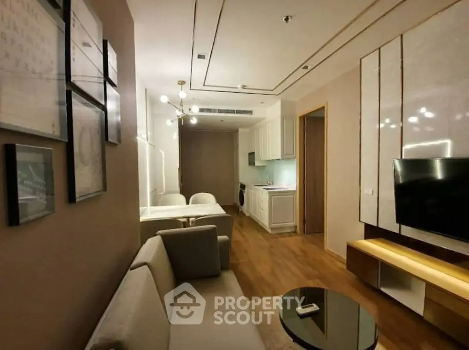 Modern living room with open kitchen, stylish decor, and cozy seating area in a contemporary apartment.