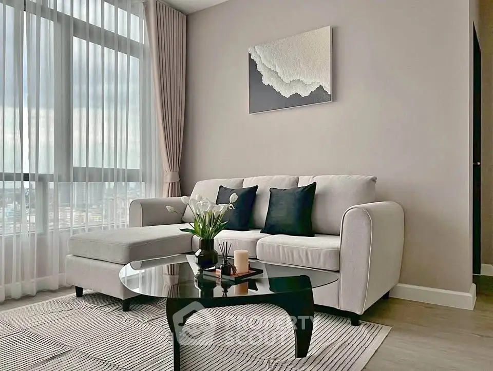 Elegant living room with modern sofa, chic decor, and large window offering natural light.