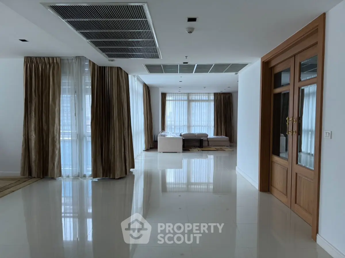 Spacious modern living area with large windows and elegant curtains