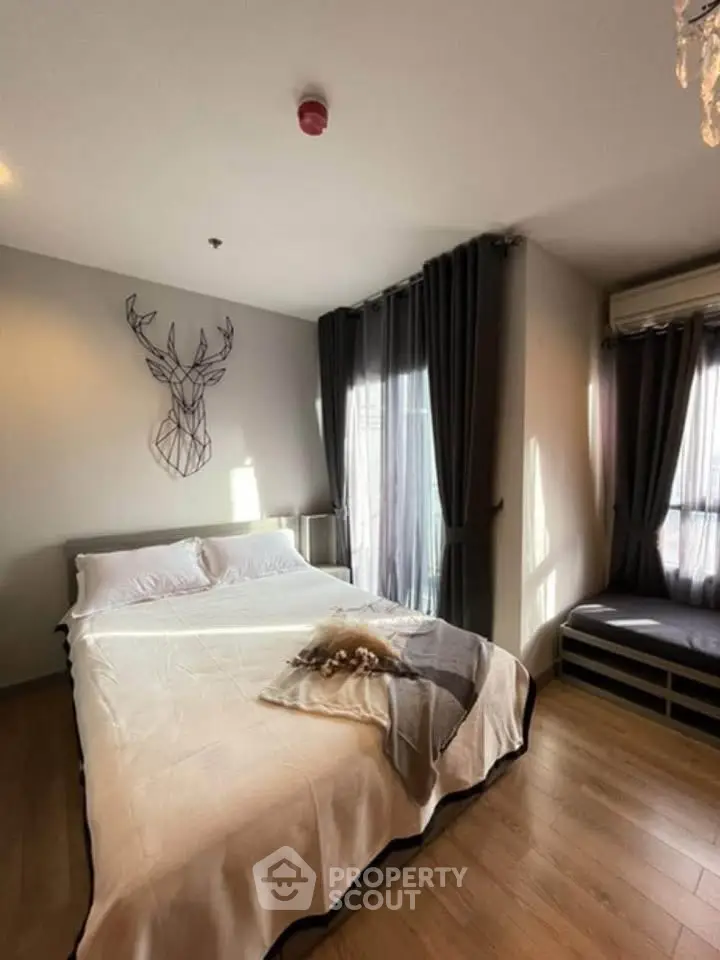 Cozy bedroom with modern decor and natural light, featuring a stylish wall art and elegant curtains.