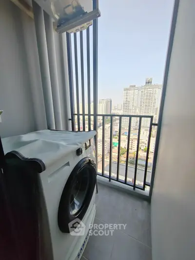 Compact balcony with washing machine and city view in modern apartment.