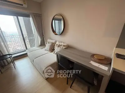 Modern living room with city view, featuring cozy sofa and stylish desk setup.
