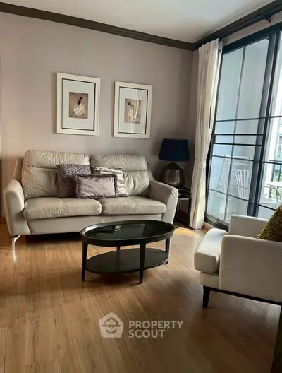 Chic living room with modern furniture and large windows offering natural light.