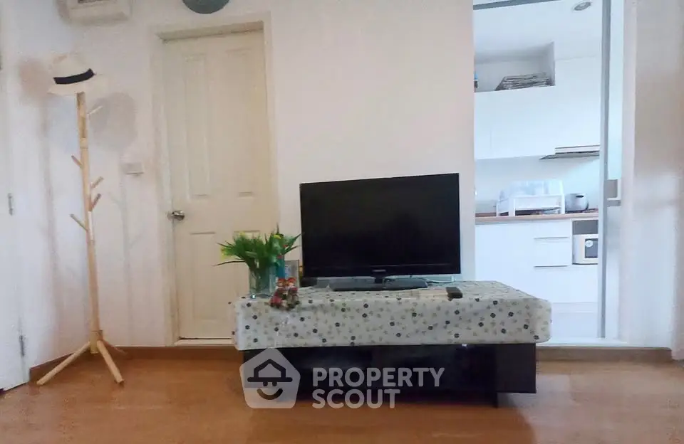 Cozy living room with TV and view into modern kitchen