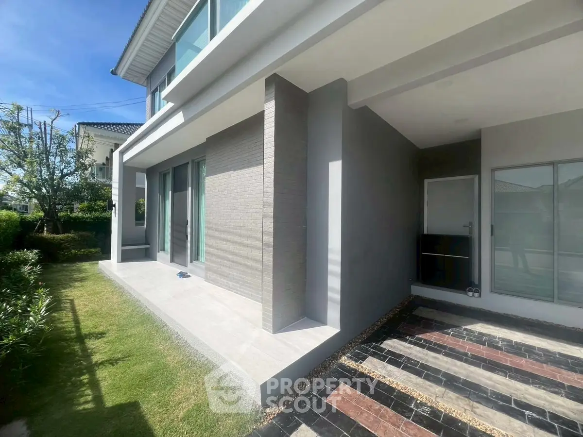 Modern house exterior with sleek design and spacious patio in sunny setting.