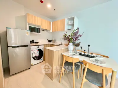 Modern kitchen with dining area, featuring sleek appliances and stylish decor in a cozy open layout.