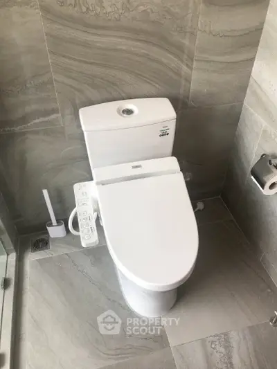 Modern bathroom with sleek toilet and elegant stone tiles