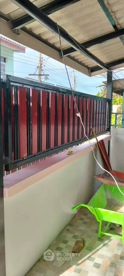 Charming balcony with tiled floor and vibrant red railing, perfect for relaxing outdoors.