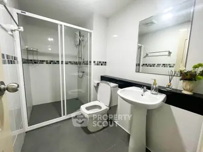 Modern bathroom with glass shower enclosure and sleek fixtures