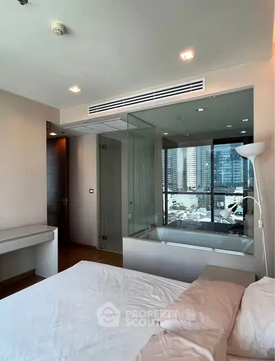 Luxurious bedroom with city view and modern glass-enclosed bathtub, perfect for urban living.
