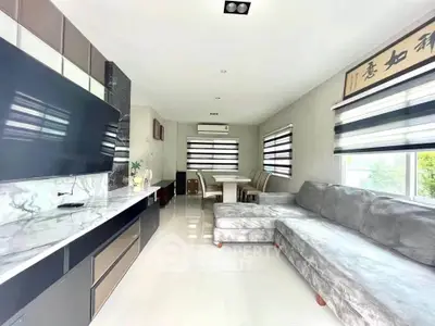 Modern living room with sleek furniture and large windows for natural light.