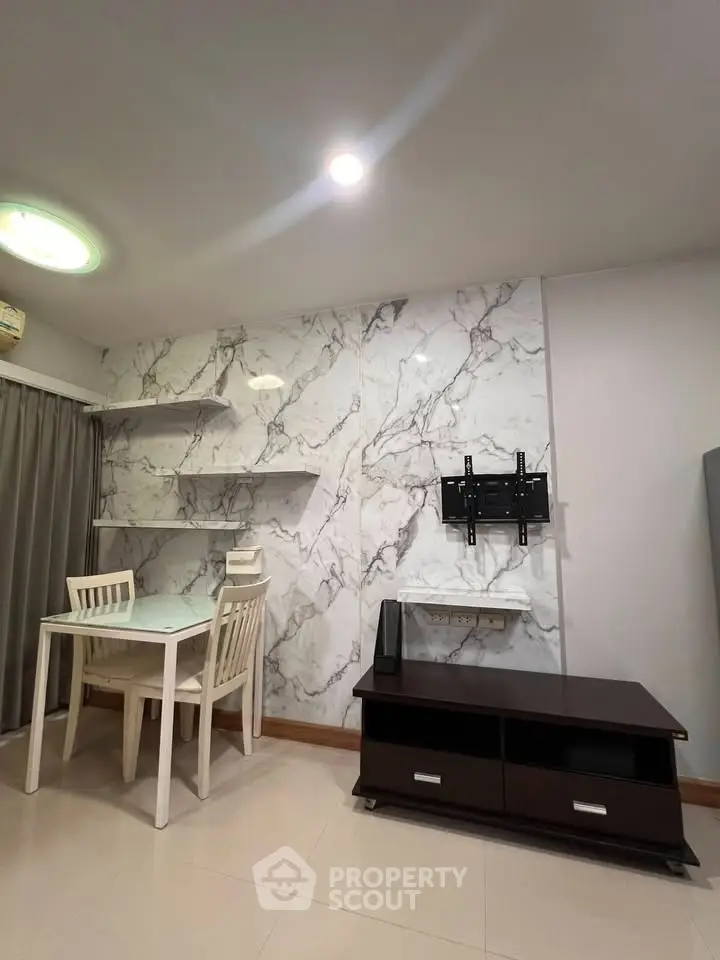 Modern living room with marble accent wall, sleek furniture, and built-in TV mount.