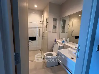 Modern bathroom with glass shower and sleek fixtures in a contemporary home.