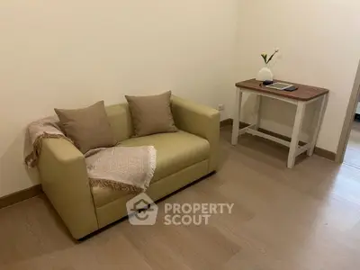 Cozy living room with beige sofa and wooden side table, perfect for relaxation.