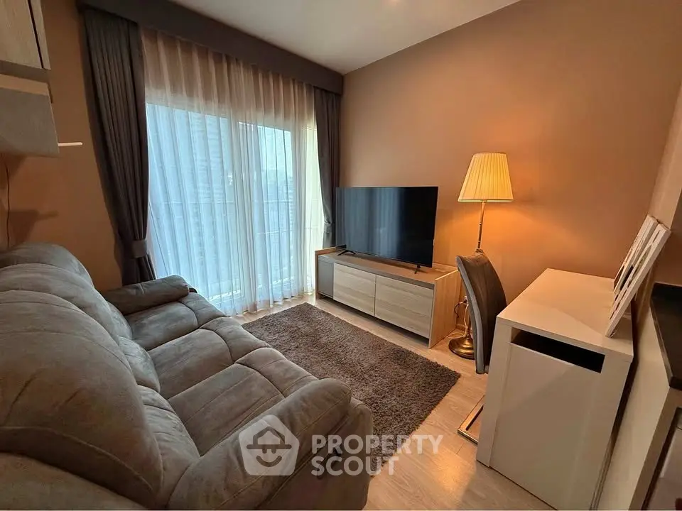 Cozy living room with plush sofa, large TV, and elegant lighting, perfect for relaxation and entertainment.