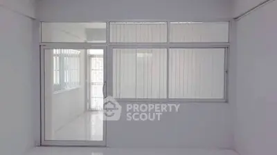 Spacious room with large windows and sliding glass door, perfect for natural light.