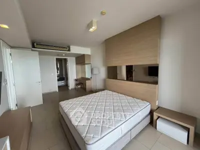 Spacious modern bedroom with stylish wooden accents and ample natural light.
