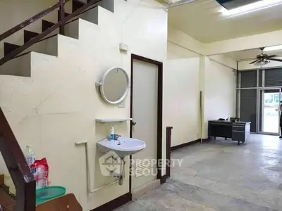 Spacious interior with staircase and sink, ideal for versatile use in a commercial or residential setting.