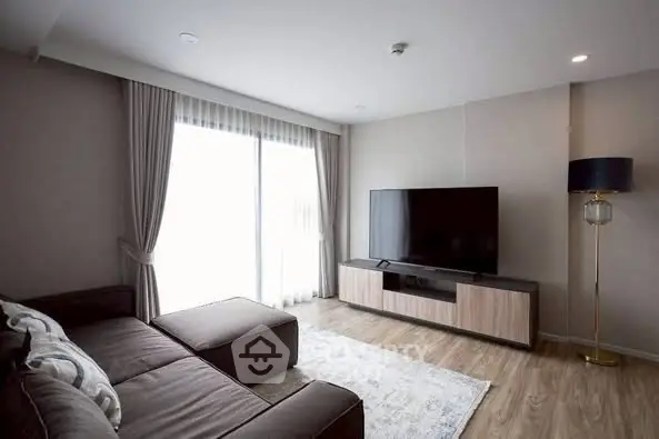 Modern living room with sleek furniture and large TV, perfect for relaxation.