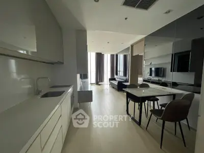 Modern open-layout kitchen and living room with sleek design and natural light.