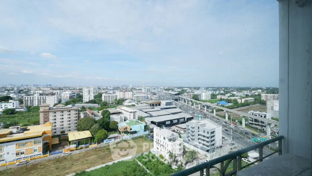 Stunning cityscape view from high-rise balcony overlooking urban skyline and green spaces.