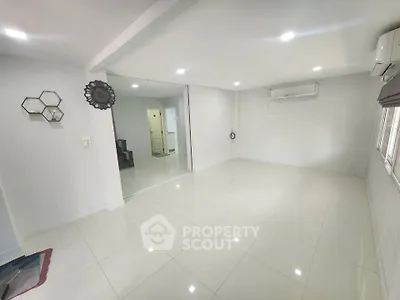 Spacious modern living room with sleek white tiles and air conditioning, perfect for comfortable living.